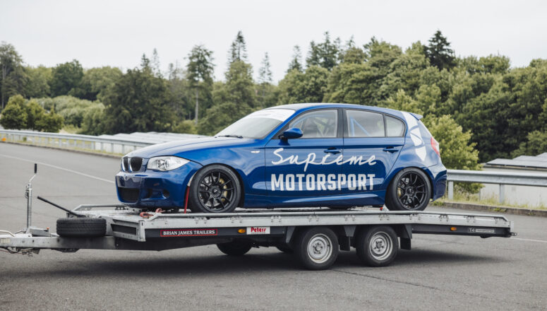 BMW E87 130i Le Mans Racer op een Brian James trailer bij circuit Bilsterberg in Duitsland