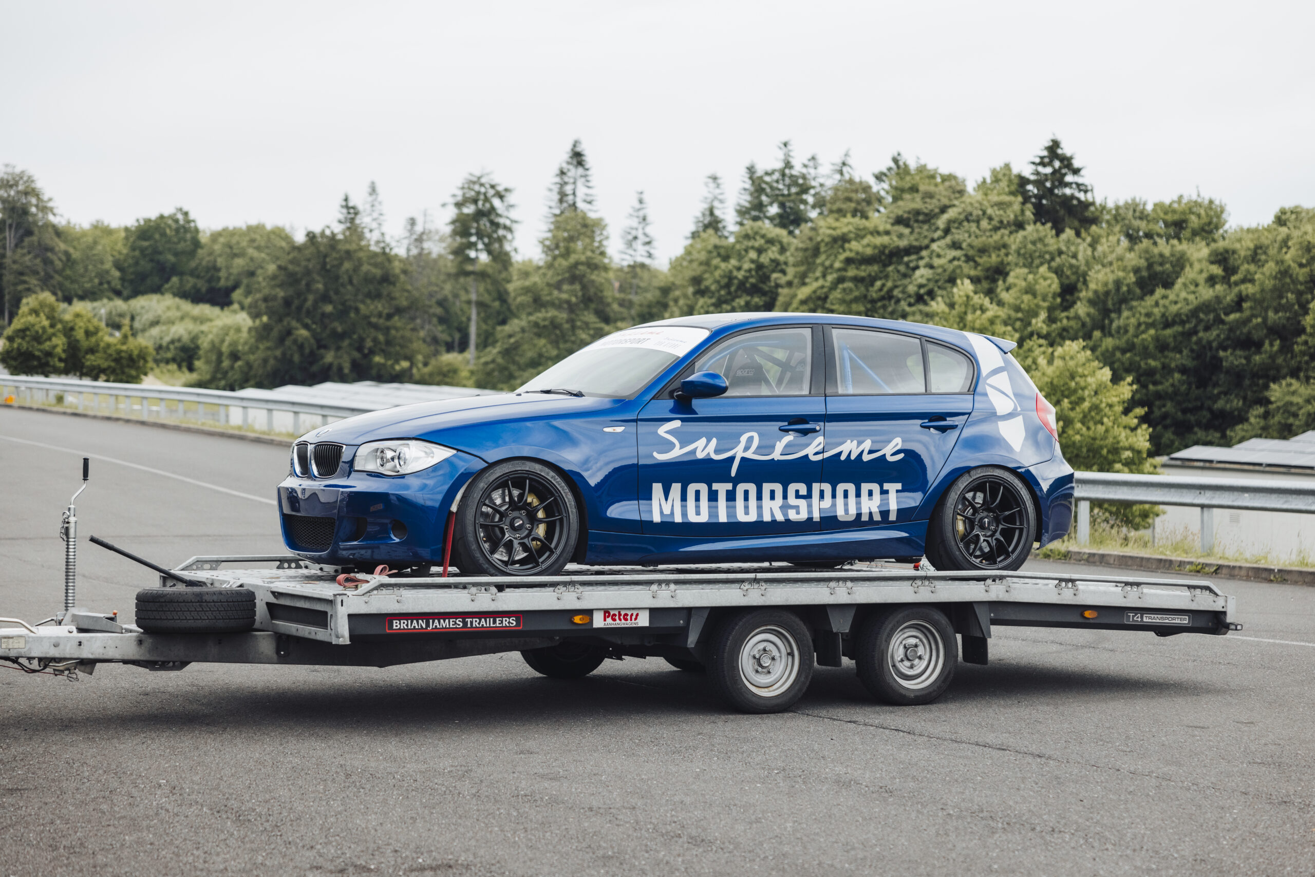 BMW E87 130i Le Mans Racer op een Brian James trailer bij circuit Bilsterberg in Duitsland