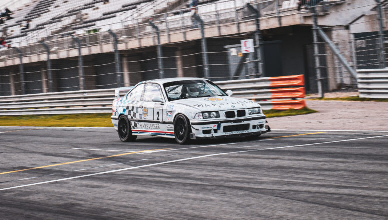 Witte raceauto rijdt op hoge snelheid op het circuit
